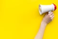 Attract attention concept. Megaphone in hand on yellow background top view copy space Royalty Free Stock Photo