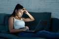 Attractive addictive young woman working late at night on her laptop at home Royalty Free Stock Photo