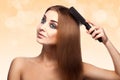 Attractive adult caucasian girl with blue eyes combing her perfect brown healthy streight hair with comb Royalty Free Stock Photo