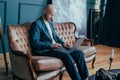 Attractive adult successful surprised bald man with beard in suit working at laptop on his rich cabinet Royalty Free Stock Photo