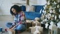 Attractive mixed race girl packing gift box near Christmas tree at home Royalty Free Stock Photo