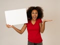 Attractive african american woman with blank board happy and surprised showing and selling product Royalty Free Stock Photo