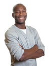 Attractive african man with crossed arms laughing at camera Royalty Free Stock Photo