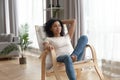 Attractive african woman leaned on wooden rocking chair resting indoors