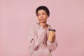 Thoughtful black girl holding paper cup with coffee over pink background Royalty Free Stock Photo