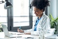 Attractive afro female doctor talking while explaining medical treatment to patient through a video call with laptop in the