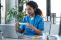 Attractive afro female doctor explaining to her patient how to put on surgical mark through a video call with laptop