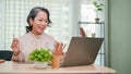 Attractive aged-asian businesswoman working on her business tasks, using laptop at her desk Royalty Free Stock Photo