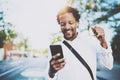 Attractive american african black man listening to music with headphones in urban background. Happy men using smartphone Royalty Free Stock Photo