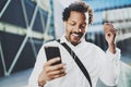Attractive american african black man listening to music with headphones in urban background. Happy men using smartphone Royalty Free Stock Photo