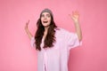 Attractive amusing positive joyful cute nice adorable tender young curly brunette woman wearing pink shirt and gray hat
