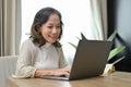 Attractive Asian-aged woman or female entrepreneur using laptop computer in her living room Royalty Free Stock Photo