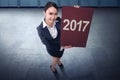 Attractive asian business woman holding 2017 greeting