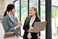 Attractive Asian businesswoman enjoys talking to her colleague while taking a coffee break Royalty Free Stock Photo