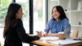 An attractive Asian businesswoman or female financial consultant enjoys talking with her client Royalty Free Stock Photo