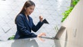 An attractive Asian businesswoman girl expressing a winning moment. Worker working on laptop at the office showing her confidence Royalty Free Stock Photo