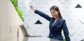 An attractive Asian businesswoman girl expressing a winning moment. Worker working on laptop at the office showing her confidence Royalty Free Stock Photo