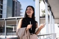 An attractive Asian businesswoman is looking away from the camera and standing outdoors Royalty Free Stock Photo