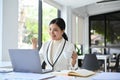 Attractive Asian businesswoman looking at laptop screen, celebrate at her office desk Royalty Free Stock Photo