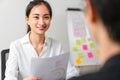 Attractive Asian businesswoman meeting and talking to brainstorm about teamwork planning on a table with laptop in the office. Royalty Free Stock Photo