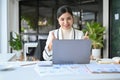 Attractive Asian businesswoman showing thumbs up while looking at her laptop screen Royalty Free Stock Photo