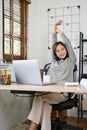 Attractive Asian businesswoman stretching her arms, relaxing after work done at her desk Royalty Free Stock Photo