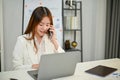 Attractive Asian businesswoman is talking on the phone with her business client Royalty Free Stock Photo