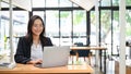 Attractive Asian businesswoman working on her project, using laptop in the co-working space Royalty Free Stock Photo