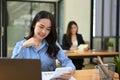 Attractive Asian businesswoman working on her task at her desk in office co-working room Royalty Free Stock Photo