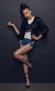 Attractive asian disco girl standing and posing at grey wall in studio Royalty Free Stock Photo