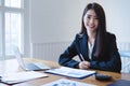 Attractive asian female accountant using calculator and discussing financial reports.finance accounting concept