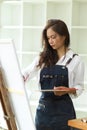 Attractive asian female artist working in her studio, passion painting, masterpiece Royalty Free Stock Photo