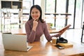 Attractive Asian female college student working on her school project, sitting in a coffee shop Royalty Free Stock Photo