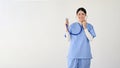 An attractive Asian female doctor stands against an isolated white background with her stethoscope Royalty Free Stock Photo