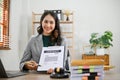 Attractive Asian female lawyer sitting at her desk, showing a business contract document Royalty Free Stock Photo