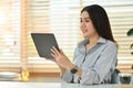 Attractive asian female marketing business manager expert using digital tablet at her working desk I bright office