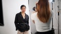 Attractive Asian female model is posing for a photographer, working in a fashion photoshoot studio Royalty Free Stock Photo