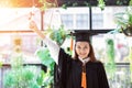 Attractive Asian Graduate woman put her hands up and celebrating with certificate in her hand and feeling so proud Royalty Free Stock Photo