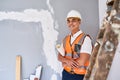 An attractive Asian supervisor manages a renovation project and smiles