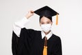 Attractive Asian woman graduated in cap and gown wear medical mask smile so proud and happiness due Virus outbrake Royalty Free Stock Photo