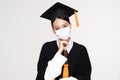 Attractive Asian woman graduated in cap and gown wear medical mask smile so proud and happiness due Virus outbrake and COVID-19 Royalty Free Stock Photo