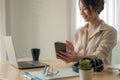 Attractive asian woman having video call via laptop and mobile phone at home office, Consultation, webinar, tutoring on Royalty Free Stock Photo