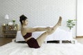 Attractive Asian woman practice yoga boat pose or Navasana pose to meditation in bedroom