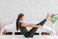 Attractive Asian woman practice yoga boat pose or Navasana pose to meditation in bedroom after wake up in the morning Royalty Free Stock Photo