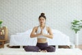 Attractive Asian woman practice yoga lotus pose to meditation in bedroom Royalty Free Stock Photo