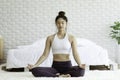 Attractive Asian woman practice yoga lotus pose to meditation in bedroom Royalty Free Stock Photo