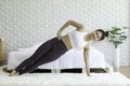 Attractive Asian woman practice yoga side plank pose to meditation in bedroom after wake up in the morning Royalty Free Stock Photo