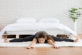 Attractive Asian woman practice yoga upavistha konasana or Seated angle pose to meditation in bedroom after wake up