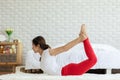 Attractive Asian woman practice yoga yoga bow or dhanurasana pose to meditation in bedroom after wake up in the morning Royalty Free Stock Photo