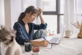 Attractive Asian woman remote working from home distance office on laptop, taking notes in notepad Royalty Free Stock Photo